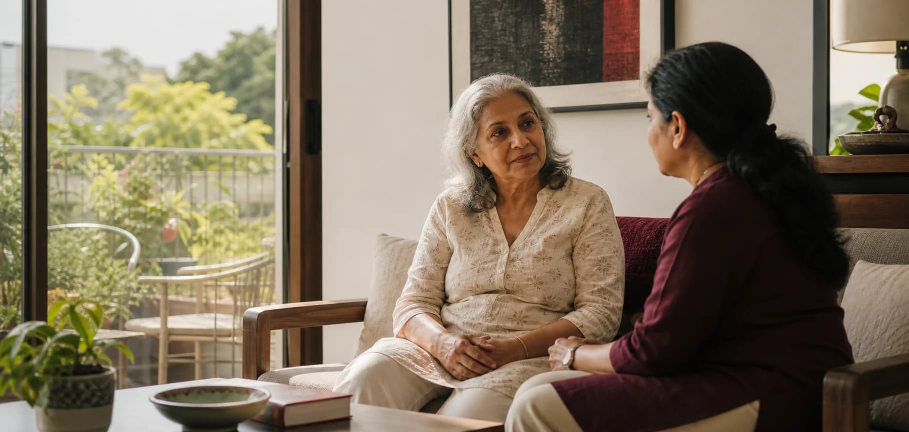 An older woman having a thoughtful conversation with a care coordinator at home